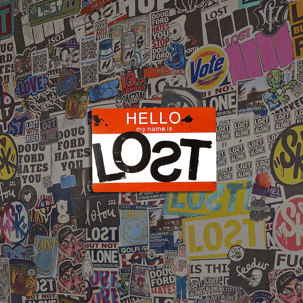 Hello my name is LOST sticker. A red and white nametag sticker stamped with the name LOST with a backwards S. The sticker is set against a colorful wall of graffiti stickers.