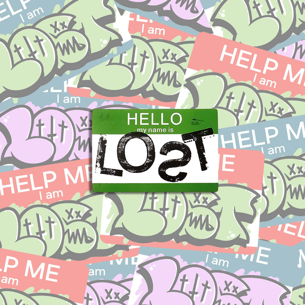 Hello my name is LOST sticker. A green and white nametag sticker stamped with the name LOST with a backwards S. The sticker is set against a collection of colorful graffiti stickers.