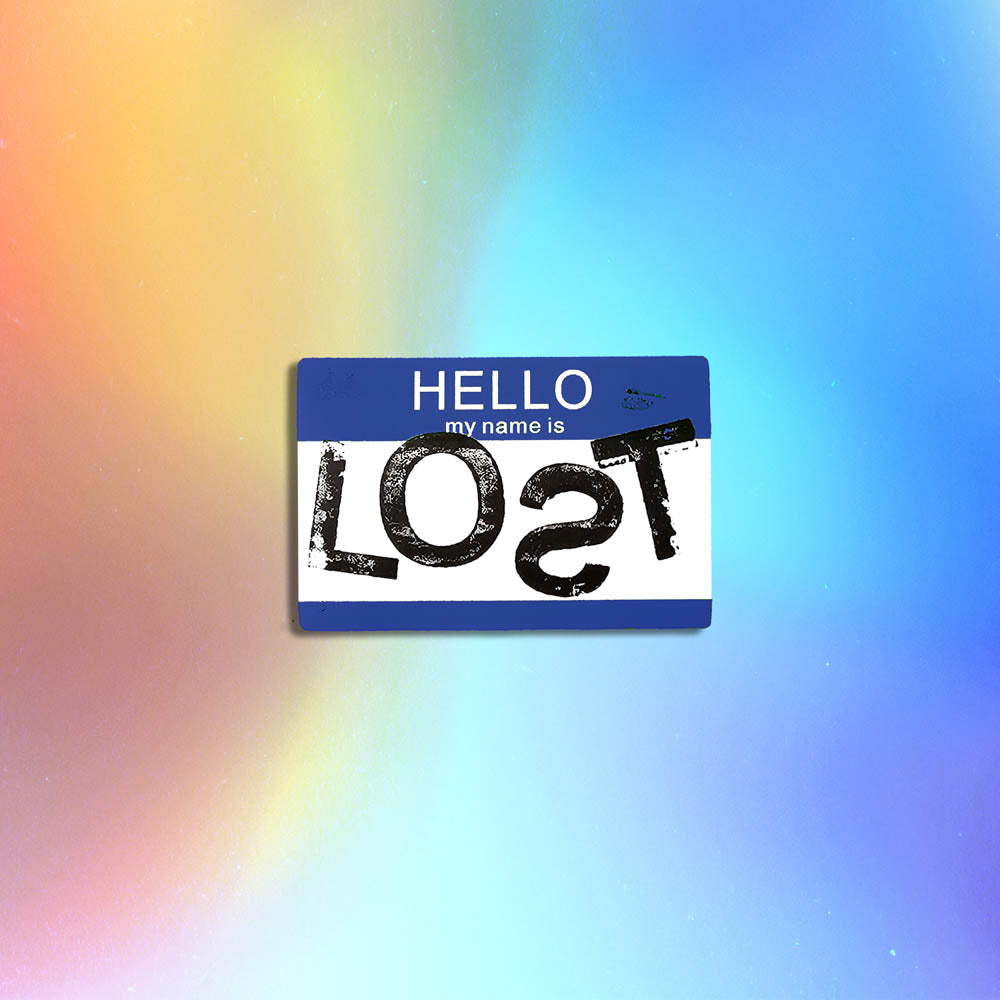 Hello my name is LOST sticker. A blue and white nametag sticker stamped with the name LOST with a backwards S. The sticker is set against a holographic background.