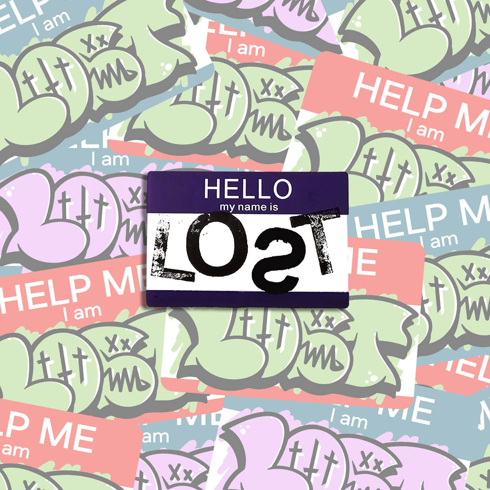 Hello my name is LOST sticker. A purple and white nametag sticker stamped with the name LOST with a backwards S. The sticker is set against a collection of colorful graffiti stickers.
