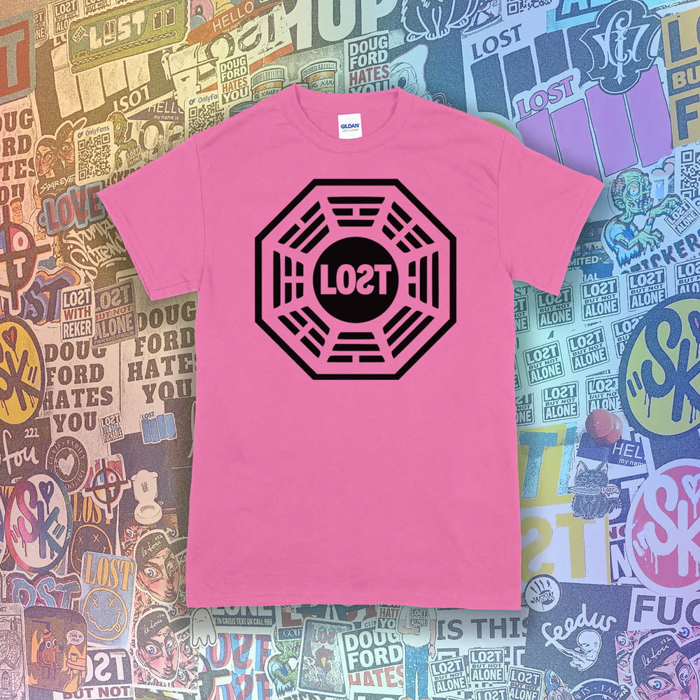 The Lost Initiative t-shirt by Lost Streetwear. The bold black logo is screen printed on a bright pink shirt. A wall of brightly colored graffiti stickers from artists around the world provides a background for the shirt.