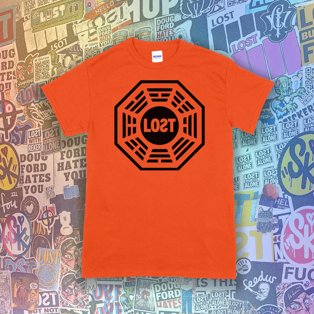 The Lost Initiative t-shirt by Lost Streetwear. The bold black logo is screen printed on a bright orange shirt. A wall of brightly colored graffiti stickers from artists around the world provides a background for the shirt.