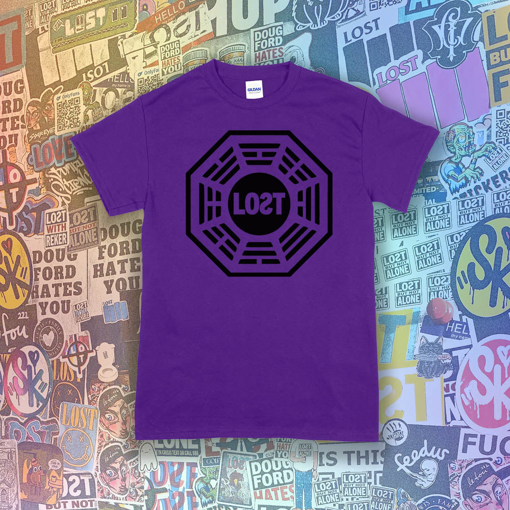 The Lost Initiative t-shirt by Lost Streetwear. The bold black logo is screen printed on a purple shirt. A wall of brightly colored graffiti stickers from artists around the world provides a background for the shirt.