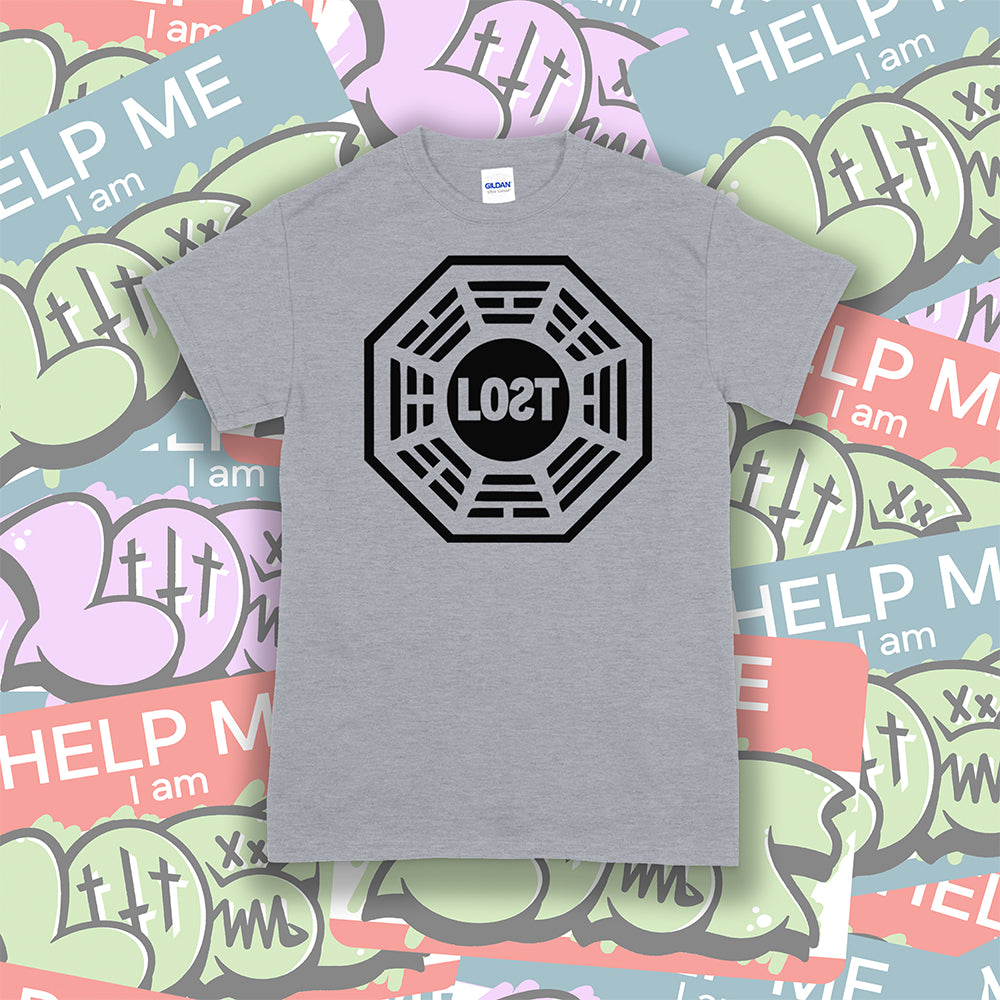 The Lost Initiative t-shirt by Lost Streetwear. The bold black logo is screen printed on a light grey shirt. A wall of brightly colored graffiti stickers make up the background.
