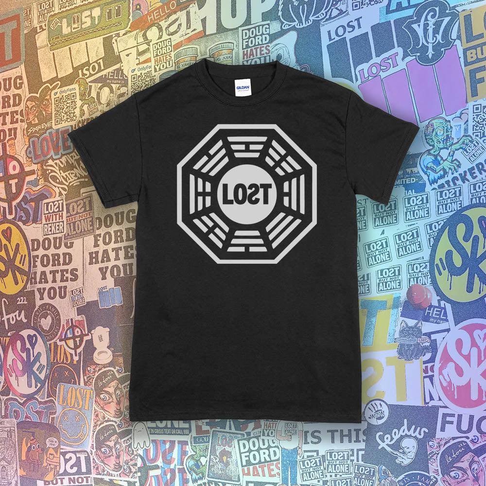 The Lost Initiative t-shirt with a large solid white logo screen printed on a black shirt. A collection of colorful LOST graffiti stickers make up the background.
