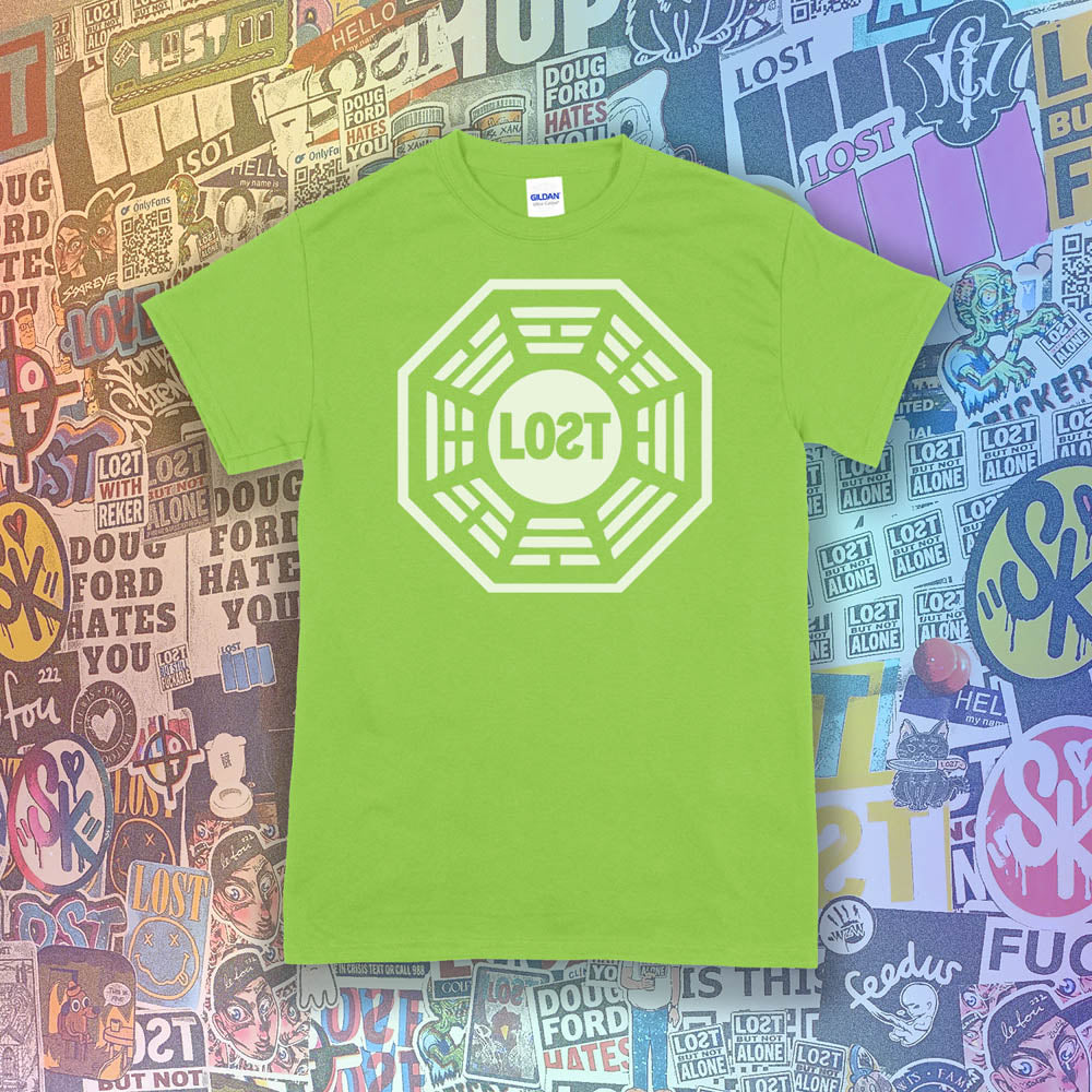 The Lost Initiative t-shirt with a large solid white logo screen printed on a lime green shirt. A collection of colorful graffiti stickers from artists all over the world make up the background.