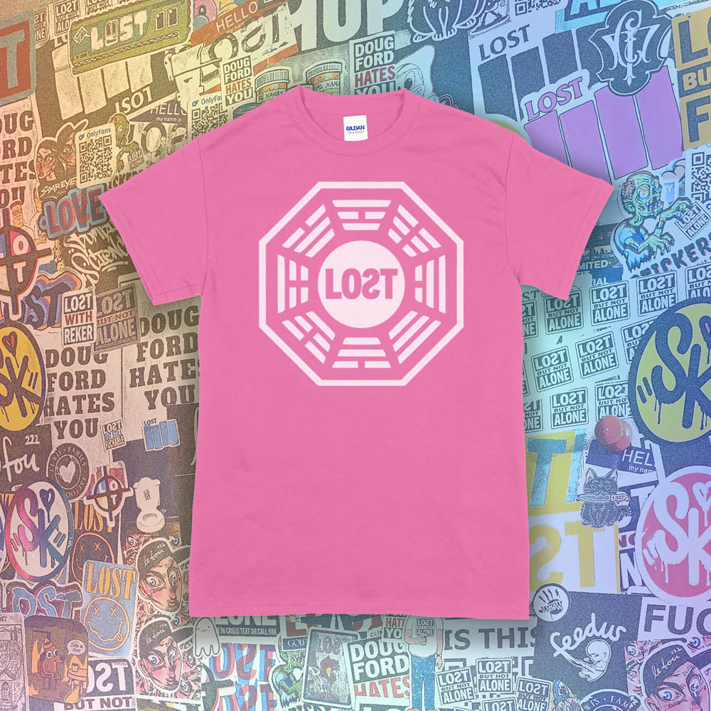 The Lost Initiative t-shirt with a large solid white logo screen printed on a bright pink shirt. A collection of colorful graffiti stickers from artists all over the world make up the background.