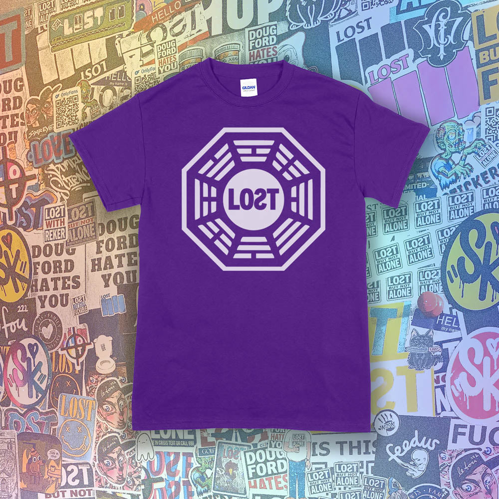 The Lost Initiative t-shirt with a large solid white logo screen printed on a purple shirt. A collection of colorful graffiti stickers by artists from around the world make up the background.