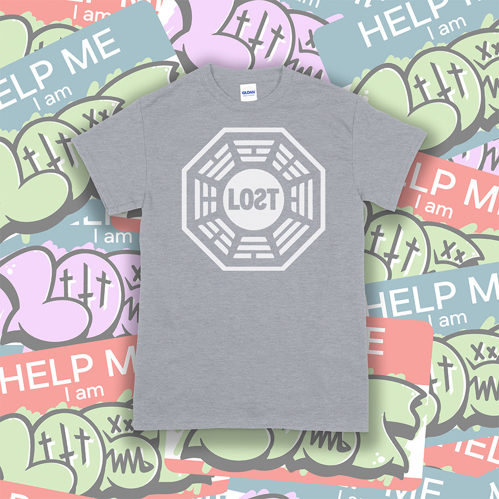 The Lost Initiative t-shirt with a large solid white logo screen printed on a grey shirt. A collection of colorful LOST graffiti stickers make up the background.