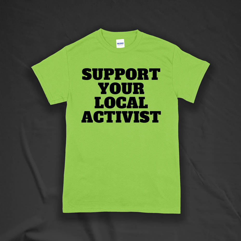The original Support Your Local Activist t-shirt by LOST. Bold black letters screen printed on a lime green shirt. The shirt is displayed against a textured black background.