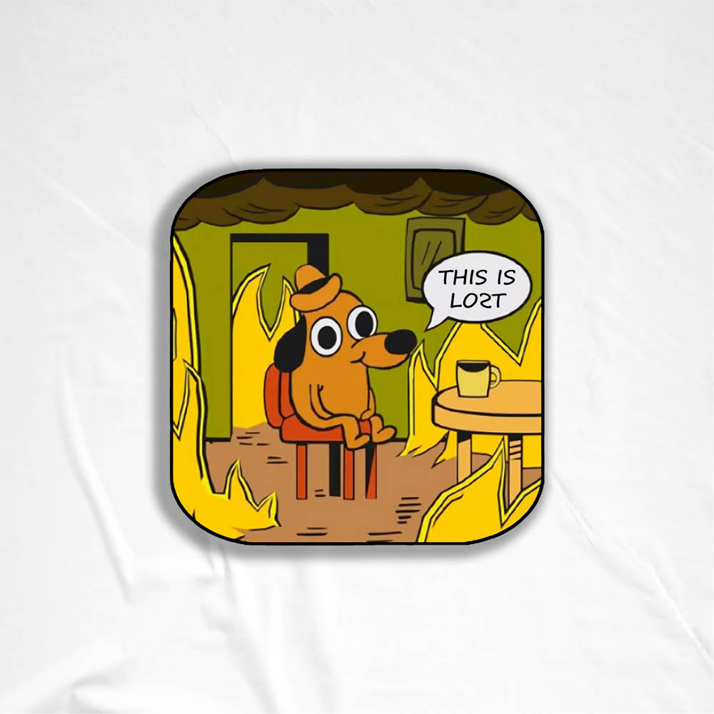 The flaming hot "This Is Fine" internet meme modified to say "THIS IS LOST". The image of a cartoon dog calmly sitting at a table with his coffee while the room burns around him is an accurate portrayal of modern day society. This sticker is set against a white textured background