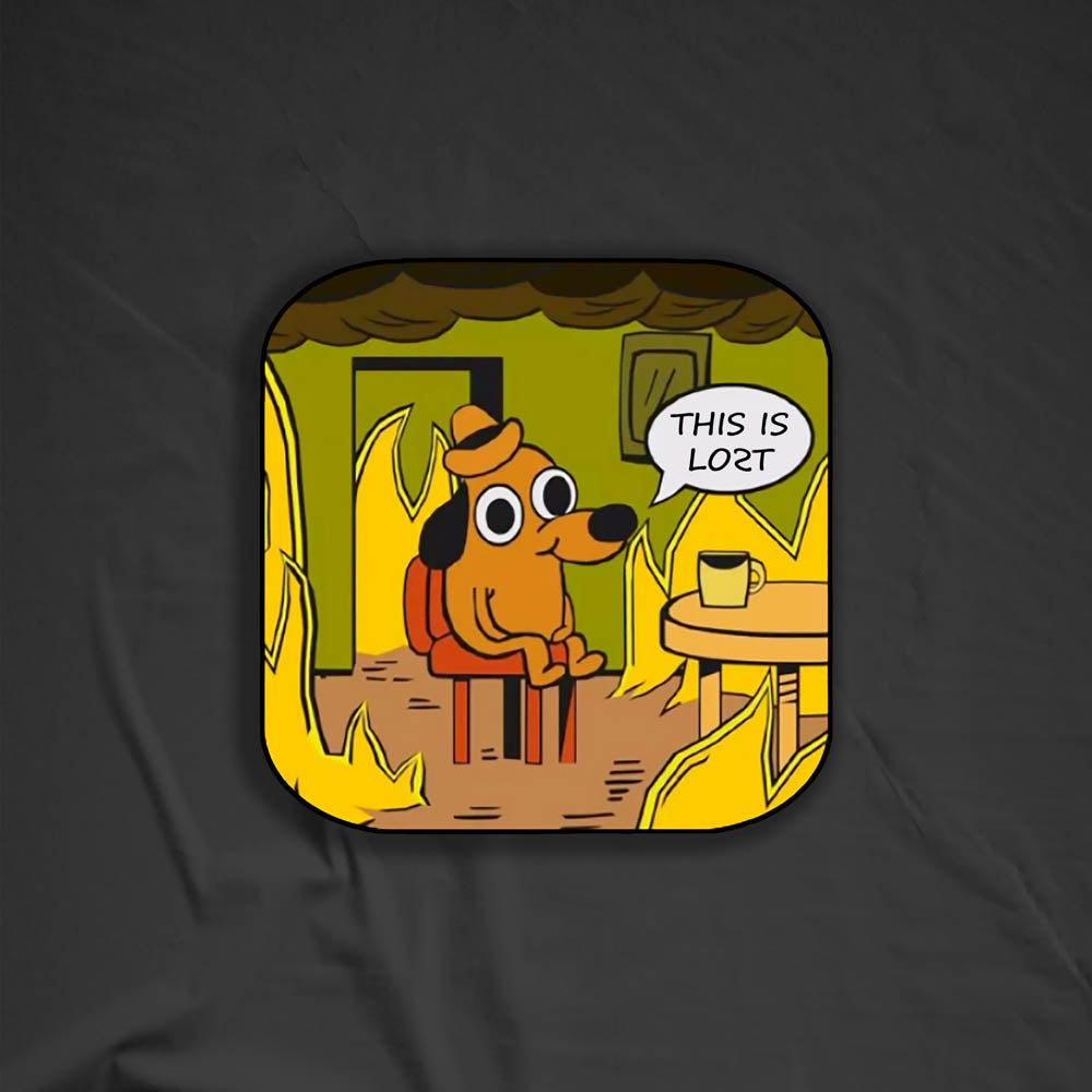 The flaming hot "This Is Fine" internet meme modified to say "THIS IS LOST". The image of a cartoon dog calmly sitting at a table with his coffee while the room burns around him is an accurate portrayal of modern day society. This sticker is set against a black textured background.