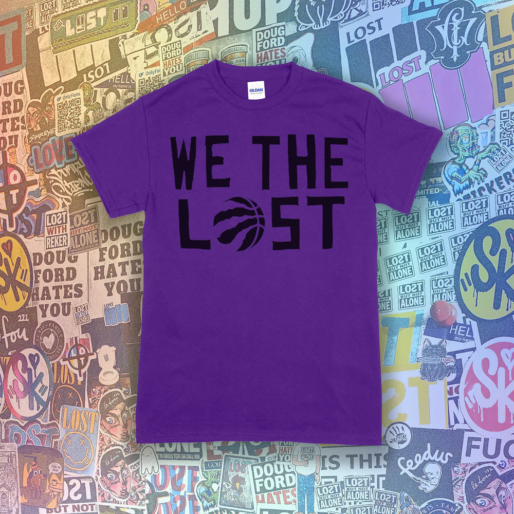 We The Lost t-shirt. Bold black lettering and raptor claw screen printed on a purple shirt. A wall of colorful graffiti stickers make up the background.