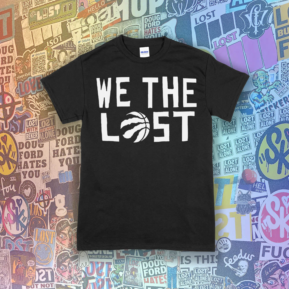 The We The Lost t-shirt. Bold white lettering and raptor claw design screen printed onto a black colored shirt. A wall of brightly colored graffiti stickers makes up the background.