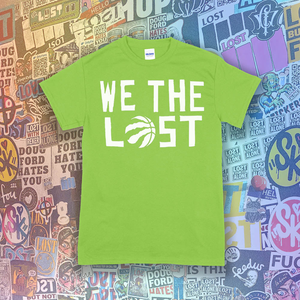 The We The Lost t-shirt. Bold white lettering and raptor claw design screen printed onto a lime green colored shirt. A wall of brightly colored graffiti stickers makes up the background.
