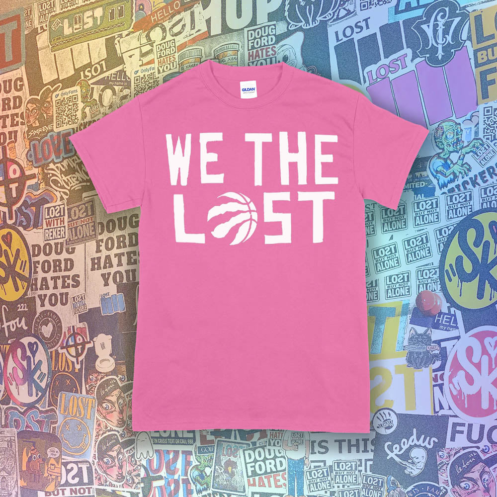 The We The Lost t-shirt. Bold white lettering and raptor claw design screen printed onto a bright pink colored shirt. A wall of brightly colored graffiti stickers makes up the background.