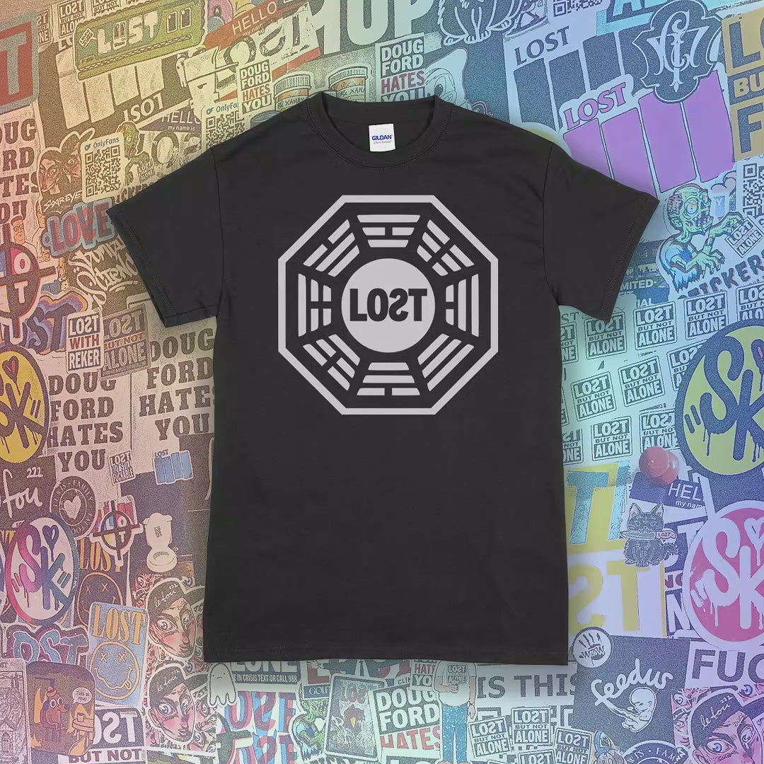The Lost Initiative t-shirt shown with a large solid white logo and displayed on a selection of different colored shirts.