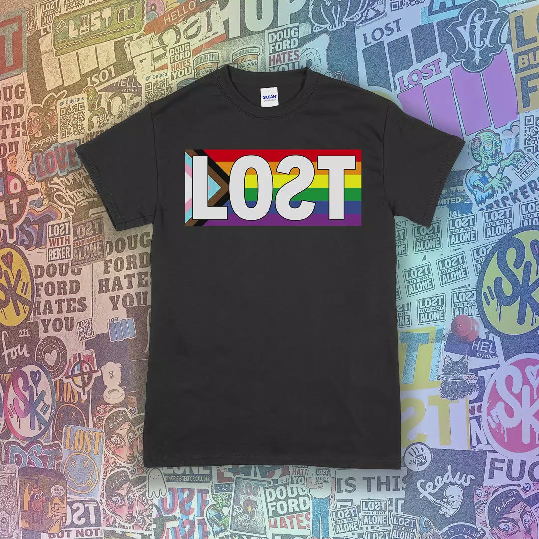 LOST progress flag shirt design by Lost Streetwear. Full color design displayed on a variety of different shirt colors. Graffiti stickers from various artists in the background.