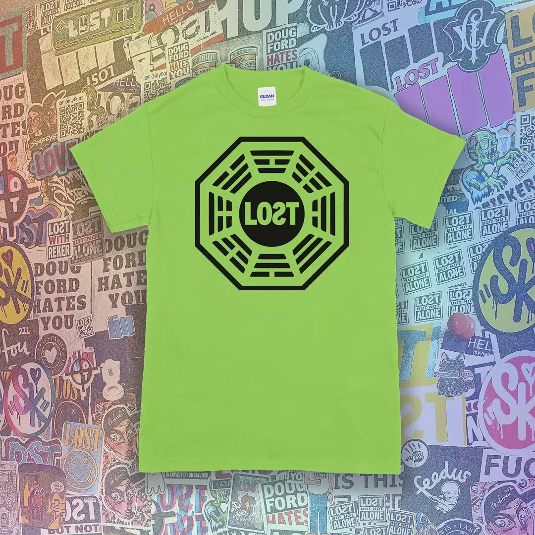 Available colors of the Lost Initiative t-shirt are shown with the black screen printed logo displayed on selection of different colored shirts. A wall of brightly colored graffiti stickers from artists around the world provides a background for the shirts.
