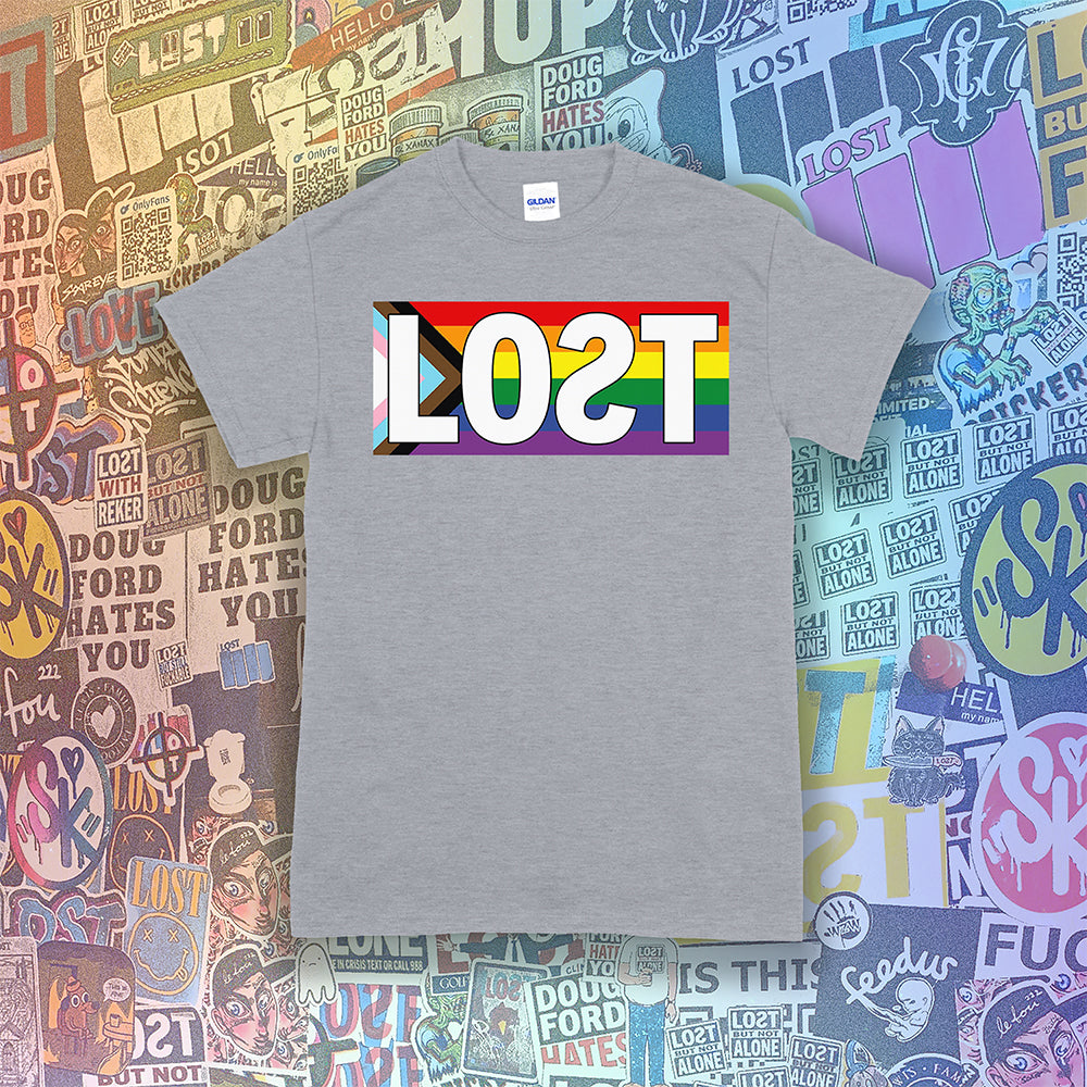 LOST progress flag shirt design by Lost Streetwear. Full color design displayed on a grey shirt. Graffiti stickers from various artists in the background.